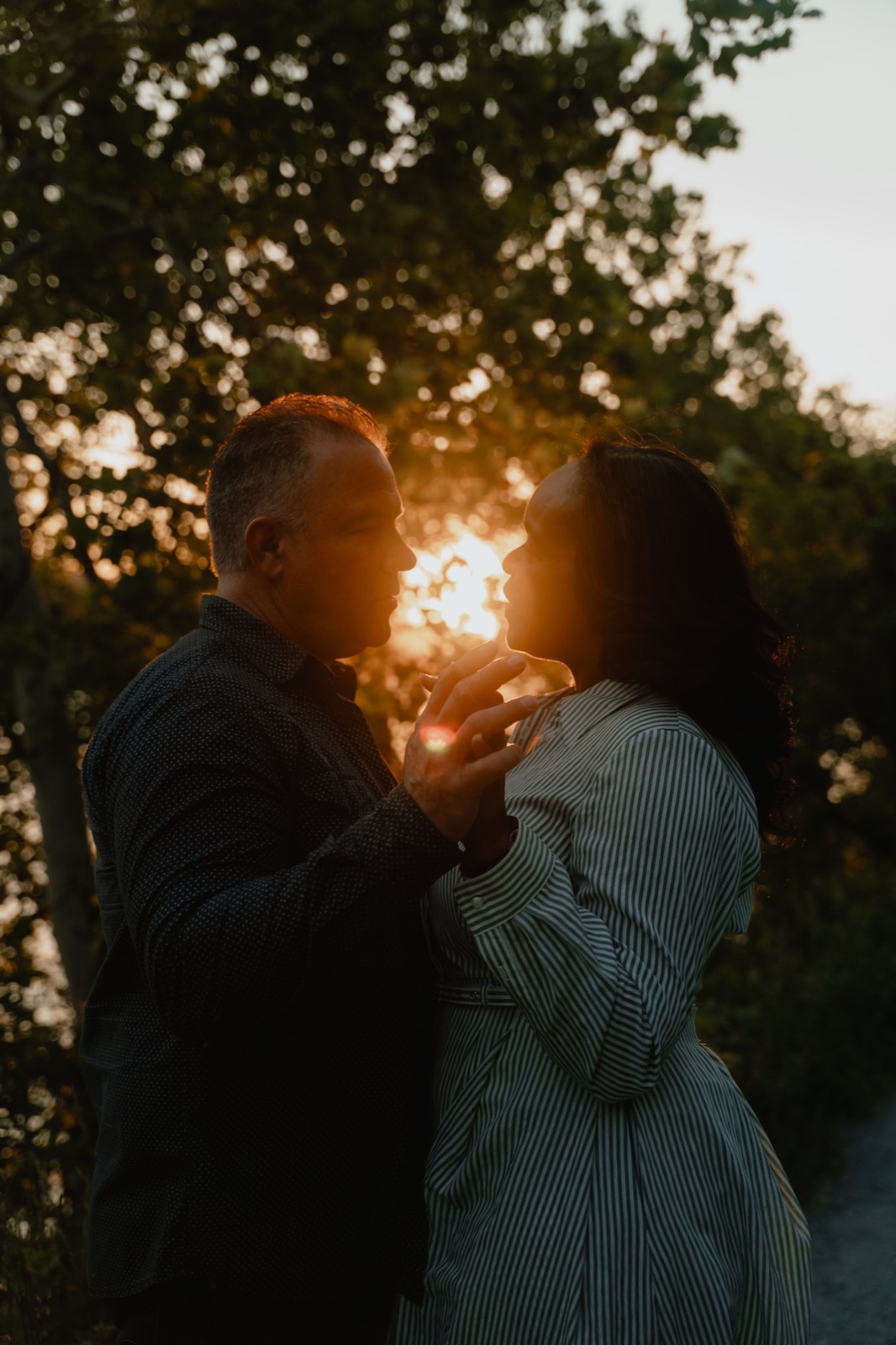 Engaged couple silhouetted against the sunset