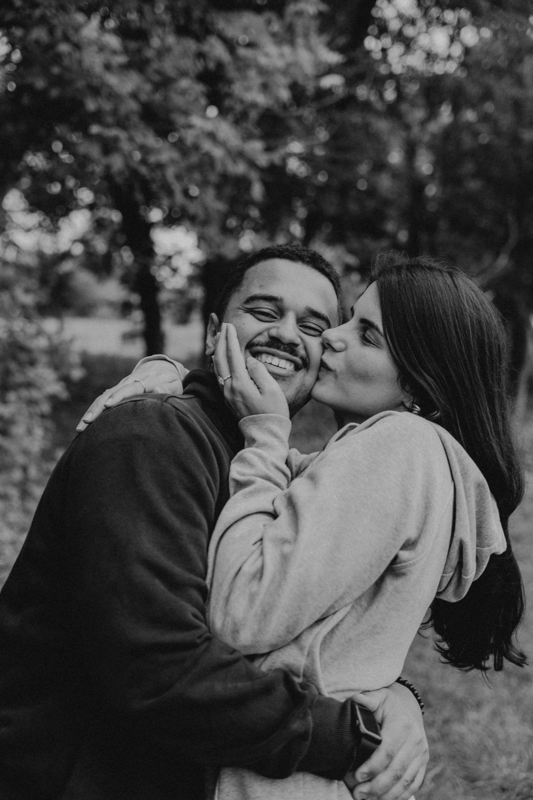 Engaged couple laughing together outdoors